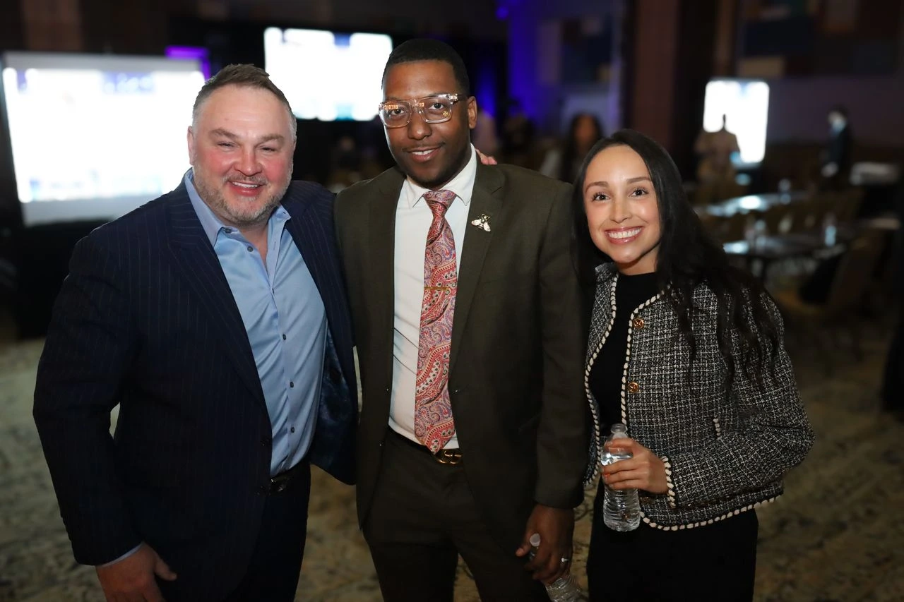 Aton smiling with two fellow event attendees